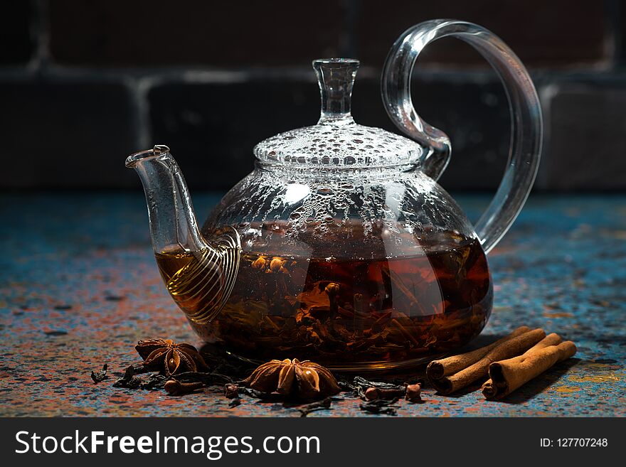 Tea masala in a glass teapot on dark background, closeup