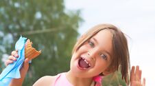 Pretty Little Girl Eating Licking Big Ice Cream In Waffles Cone Happy Laughing On Nature Background Stock Image