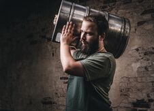 Brewer In Apron Holds Barrel With Craft Beer At Brewery Factory. Stock Photos