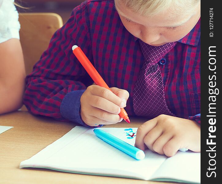 Boy Is Painting A Picture. A Beautiful Child With Felt-tip Pens Sits At The Table And Is Engaged In Creativity And Art