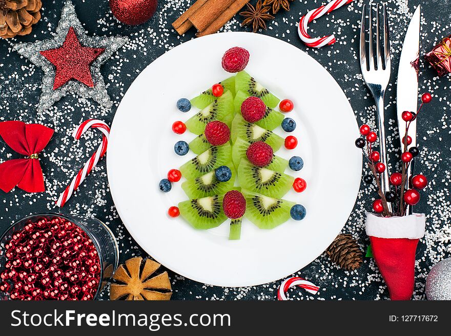 Kiwi Christmas Tree With Raspberry, Blueberry And Cowberry On Table With Decoration