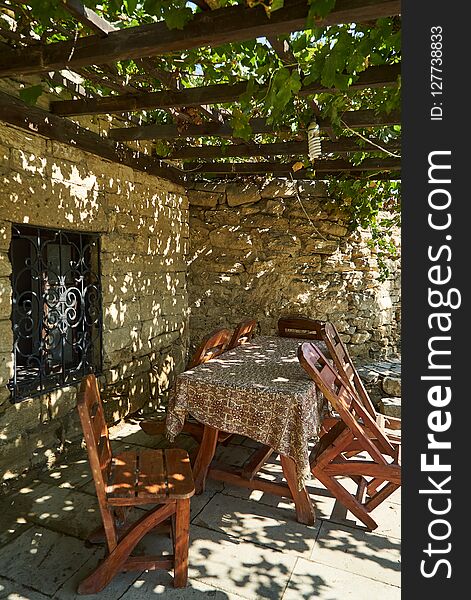 Old Fashioned Cafe Terrace With Tables, Chairs And Trees