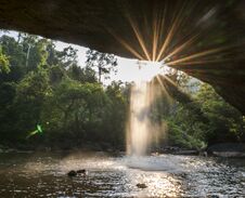 View From Cave At Beautiful Waterfall With Sunlight In Jungle, Haew Suwat Waterfall. Stock Photos View From Cave At Beautiful Waterfall With Sunlight In Jungle, Haew Suwat Waterfall. Stock Photos