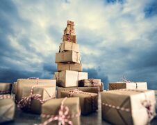 Pile Of Christmas Gifts Wrapped In Brown Paper Against The Clou Stock Images