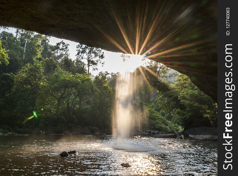 View from cave at Beautiful waterfall with sunlight in jungle, Haew Suwat Waterfall.
