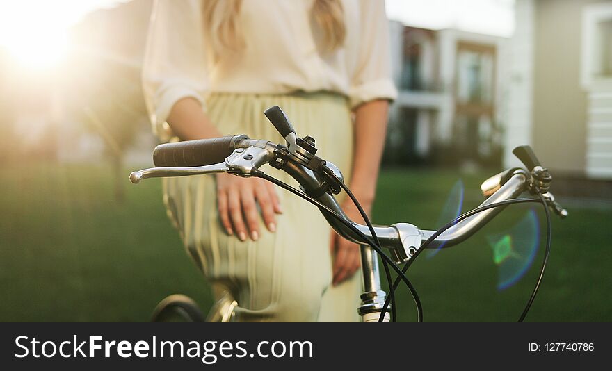 Close up hands of a young girl on vintage bicycle in park.