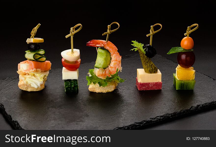 Different Kind Of Snaks, Small Canape With Cherry Tomatoes, Cheese, Sausages, Vegetables And Fruits On Skewers