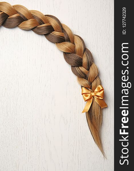 Braid and space for text on light background, top view. Healthy hair