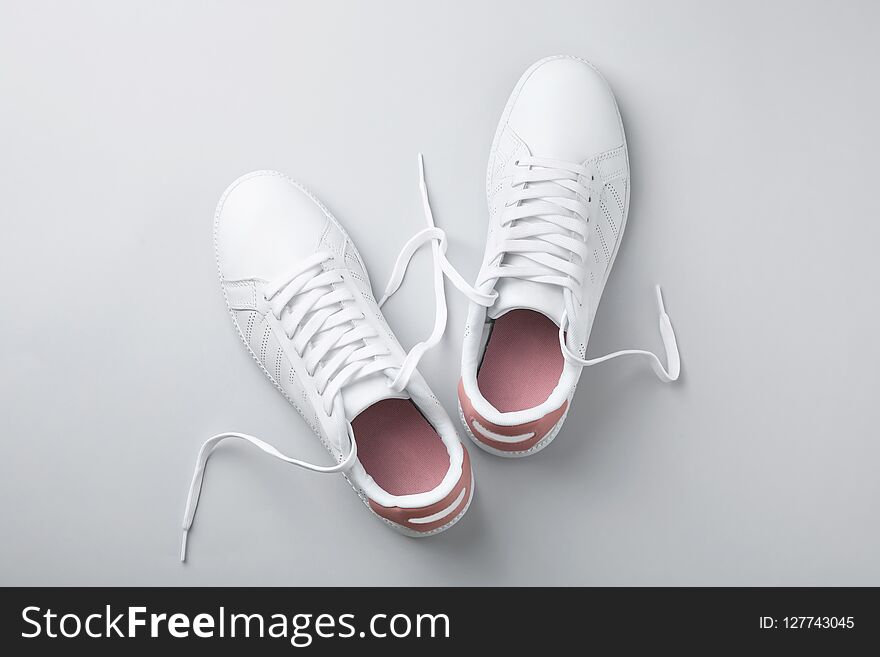 Pair of trendy sneakers on light background, flat lay