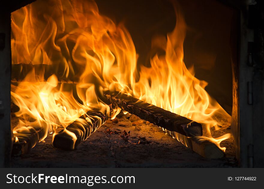 Close up of roaring fire burning brightly in fireplace. Warmth in winter time.