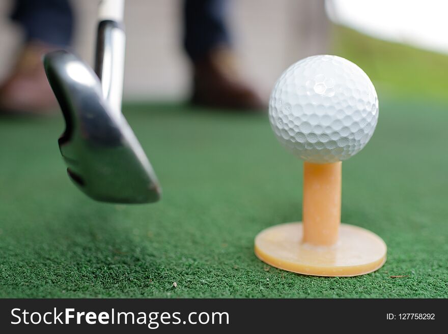 Golf balls and golf club on green grass golf