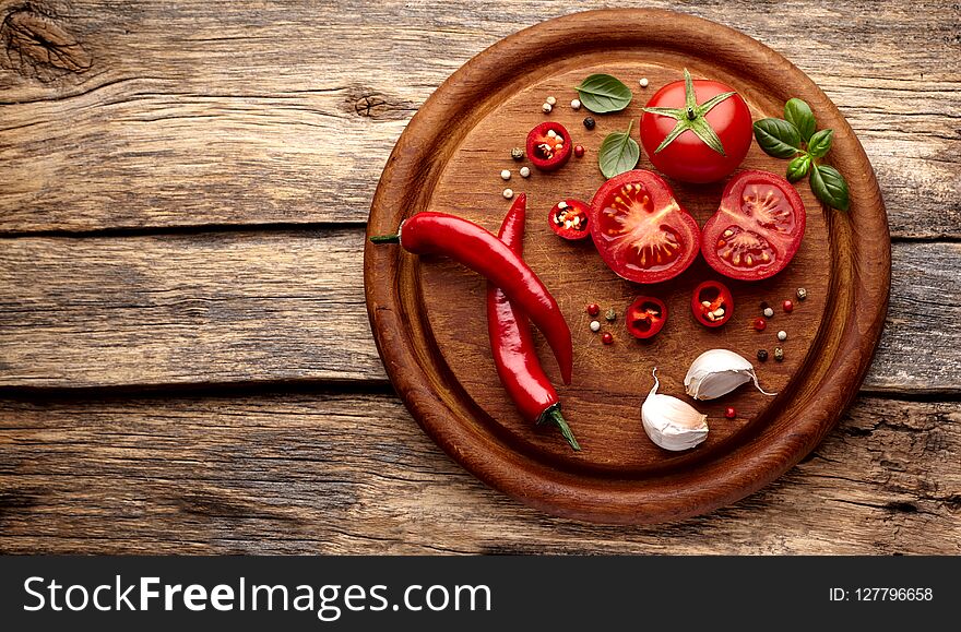 Fresh tomatoes, basil, pepper on wooden desk background. Top view