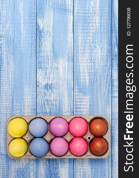 Easter eggs colored chicken on the colored, blue, wooden, background closeup. Easter eggs colored chicken on the colored, blue, wooden, background closeup