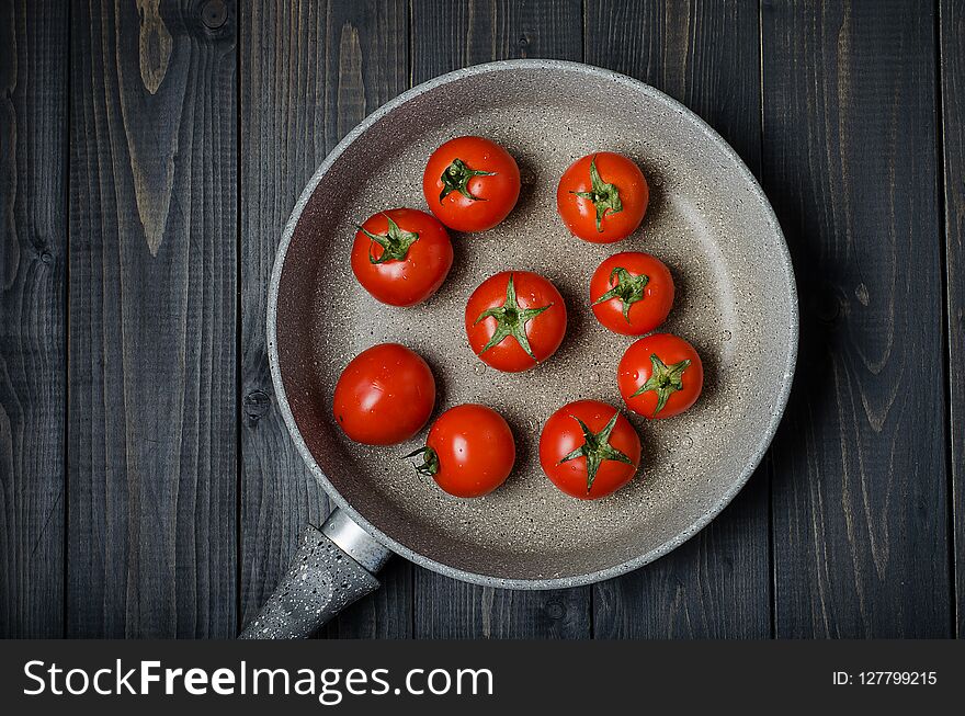 Ripe, fresh tomatoes on dark rustic wooden background. Organic, healthy, raw, vegetarian food. Ripe, fresh tomatoes on dark rustic wooden background. Organic, healthy, raw, vegetarian food.