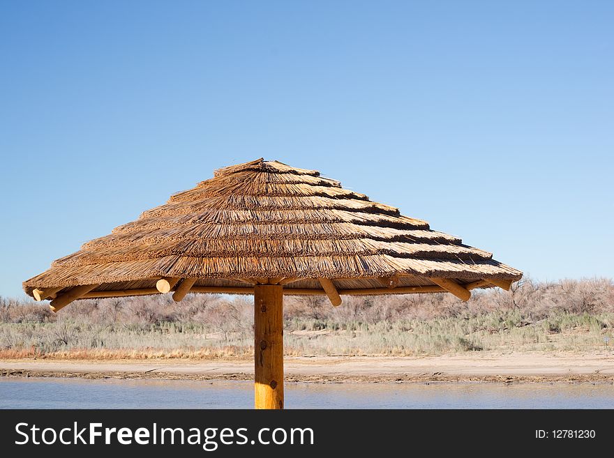 A thatched roof palapa hut invites vacationers to lounge in the shade
