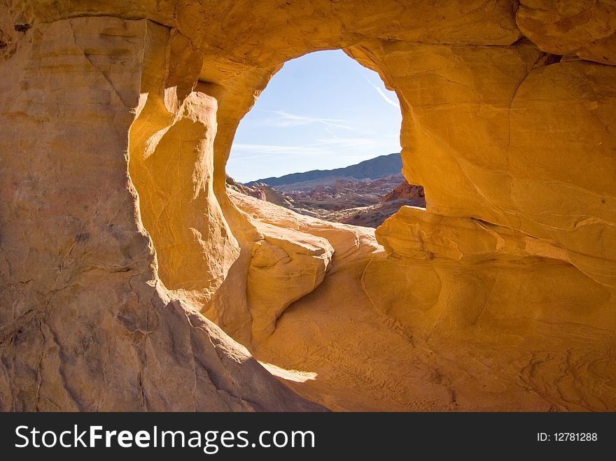 Blue desert sky shines through a keyhole opening in sandstone rock. Blue desert sky shines through a keyhole opening in sandstone rock