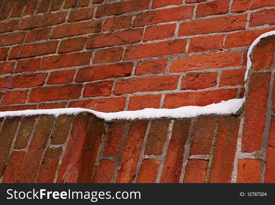 A brown brick wall with snow in Amsterdam. A brown brick wall with snow in Amsterdam