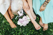 Feet Of The Bride And Her Bridesmaids On The Green Grass In Summer Time Royalty Free Stock Images