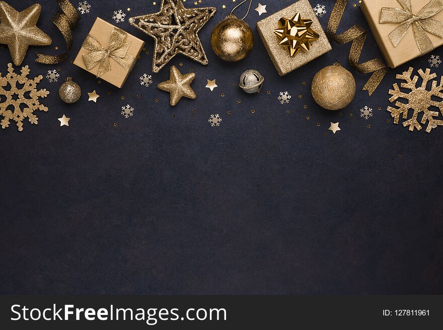 Golden snowflakes, gifts, christmas balls and stars on dark background