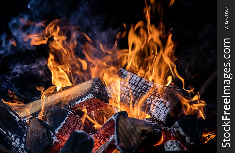 Burning wooden logs in fire, campfire isolated on black background. Burning wooden logs in fire, campfire isolated on black background