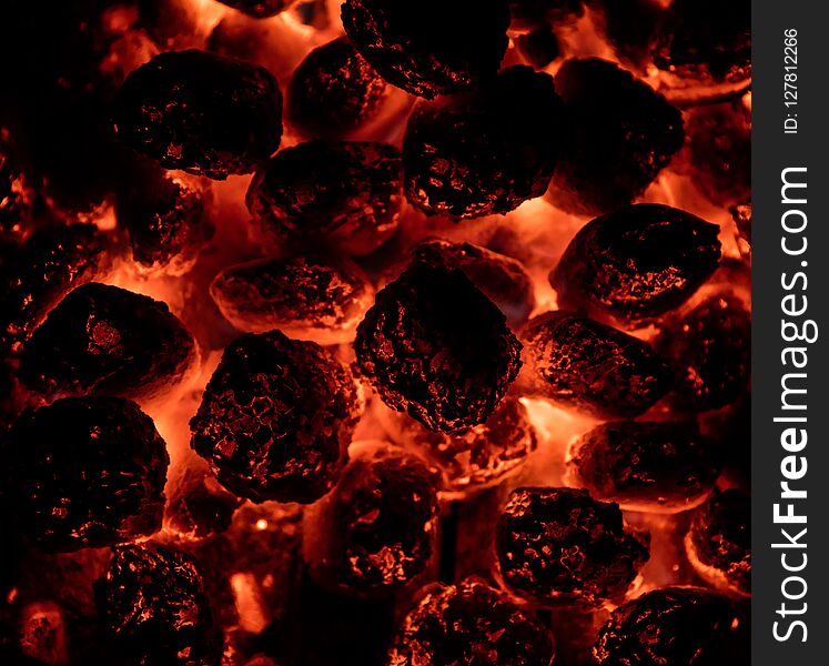 Flaming hot charcoal briquettes in detail