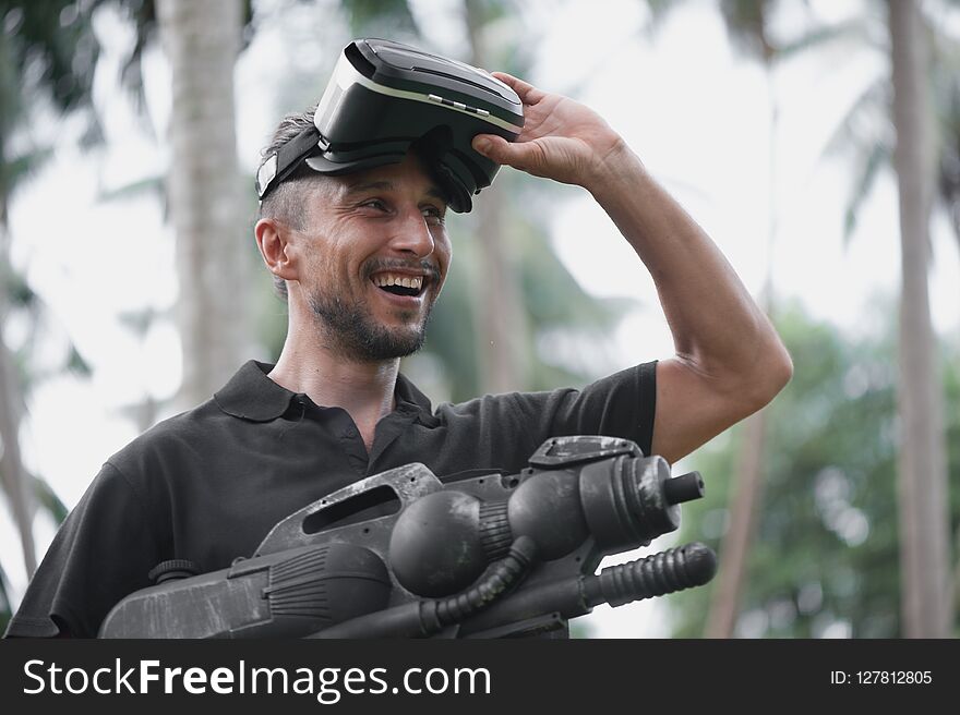 Man in virtual reality headset playing video game among palm trees. Man in virtual reality headset playing video game among palm trees