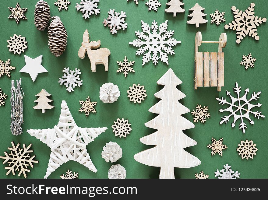Brown Wooden Christmas Decoration On Green Paper Background. Flat Lay With Ornaments Like Tree, Stars Or Sledge. Brown Wooden Christmas Decoration On Green Paper Background. Flat Lay With Ornaments Like Tree, Stars Or Sledge