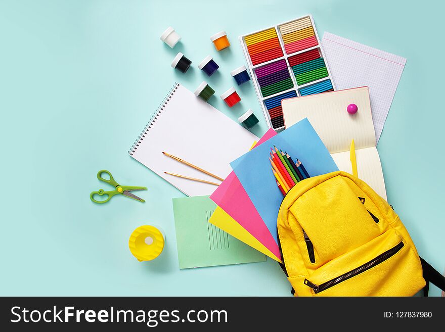 School stationary sets and knapsack on blue background.