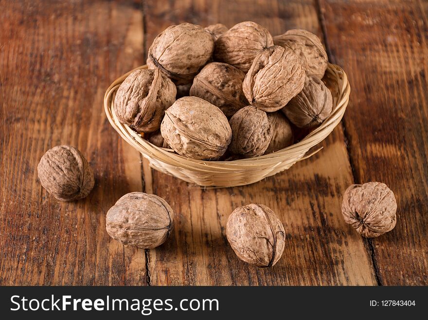 Walnuts in retro bowl and spilled on wooden desk