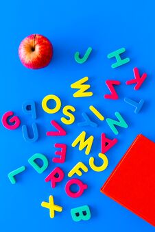 Children Learn Read Concept. Hand Hold Plastic Letters Of Toy Alphabet On Blue Background Top View Stock Photography