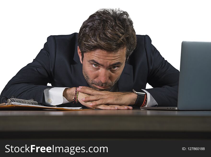 Young sad and depressed business man working overwhelmed and frustrated on laptop computer office desk feeling upset and stressed