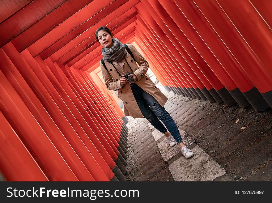 Full length photo of a confident female photographer walking in the Torii. Full length photo of a confident female photographer walking in the Torii