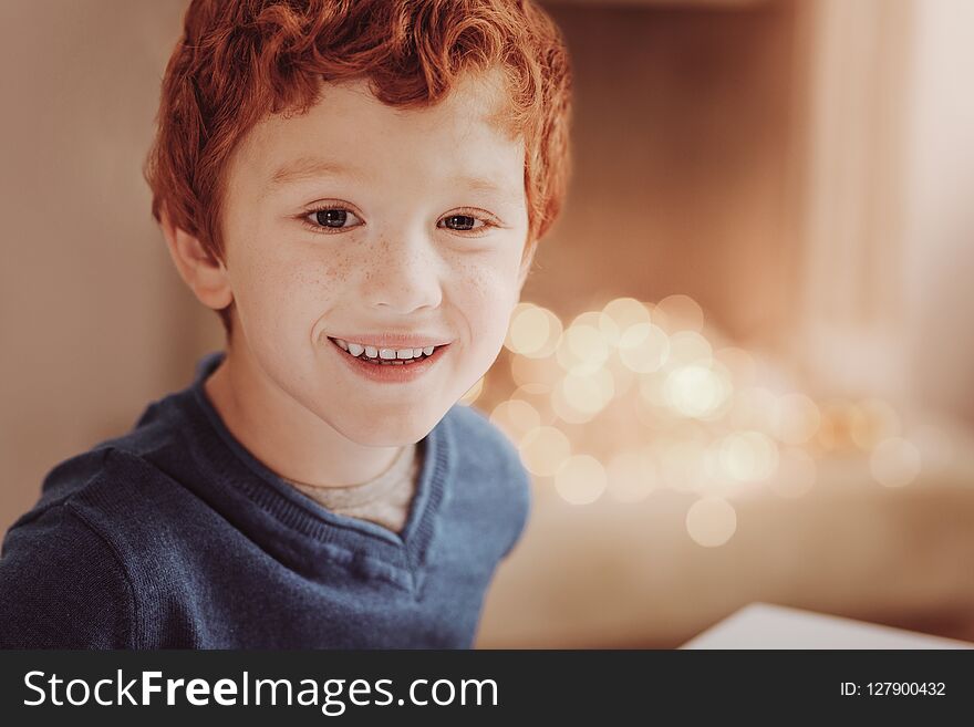 Pleasant emotions. Close up of little boy looking at you while expressing cheer on his face. Pleasant emotions. Close up of little boy looking at you while expressing cheer on his face