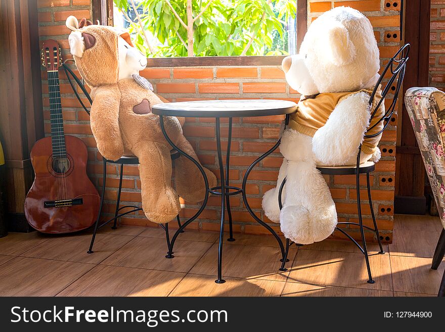 The Two embracing teddy bear toys sitting on window-sill