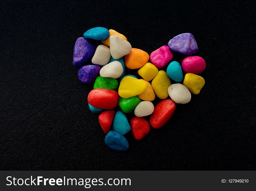 Colorful little pebbles form a heart shape