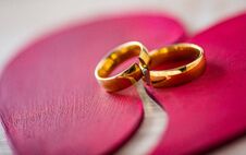 Two Broken Golden Wedding Rings On Broken Red Heart Stock Photos