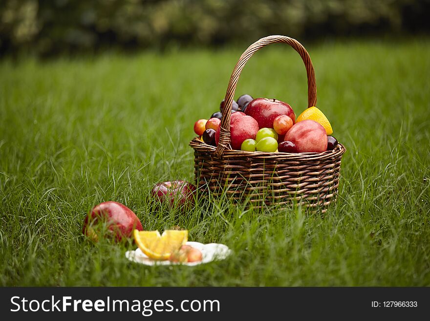Assorted fruits in a basket for picnic on grass. Assorted fruits in a basket for picnic on grass.