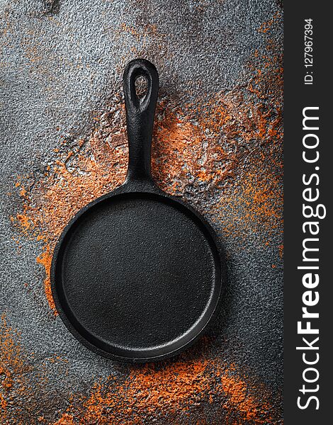 Empty black cast iron pan on an old protvine, top view