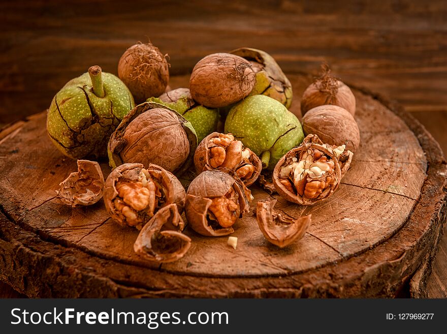 Walnuts with green leaves, on wooden background . Walnuts with green leaves, on wooden background .