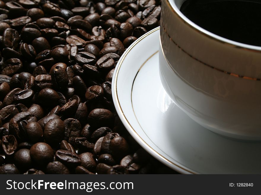 Cup of coffee on a background of fried coffee grains. Cup of coffee on a background of fried coffee grains