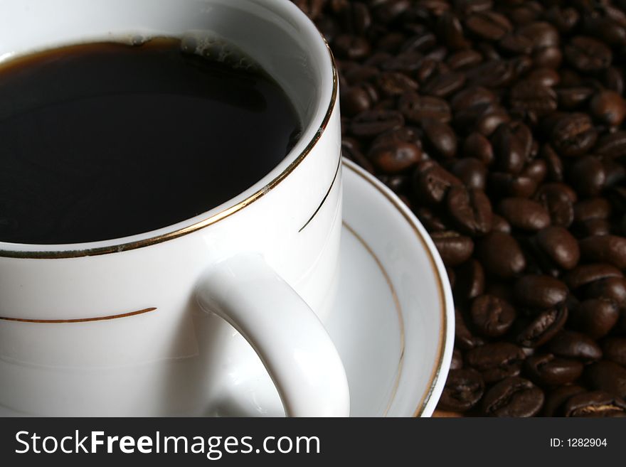 Cup of coffee on a background of fried coffee grains. Cup of coffee on a background of fried coffee grains