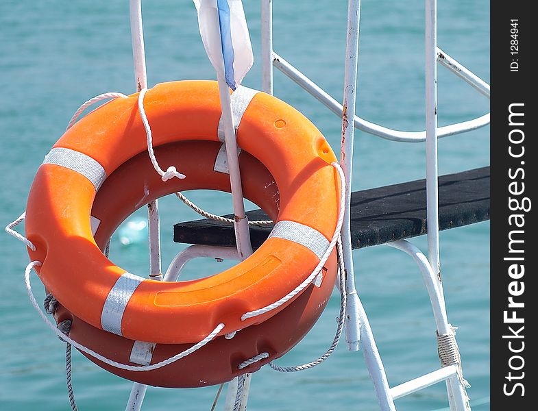 Two orange ring-buoy hanging on a metal design. Two orange ring-buoy hanging on a metal design