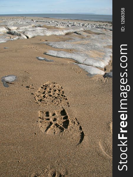 Footprint on wet sand on rock