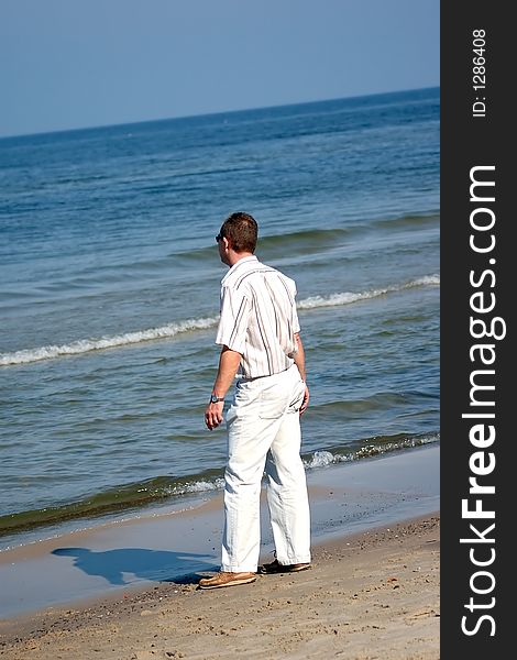 Middleaged man in official clothes standing on the beach. Middleaged man in official clothes standing on the beach