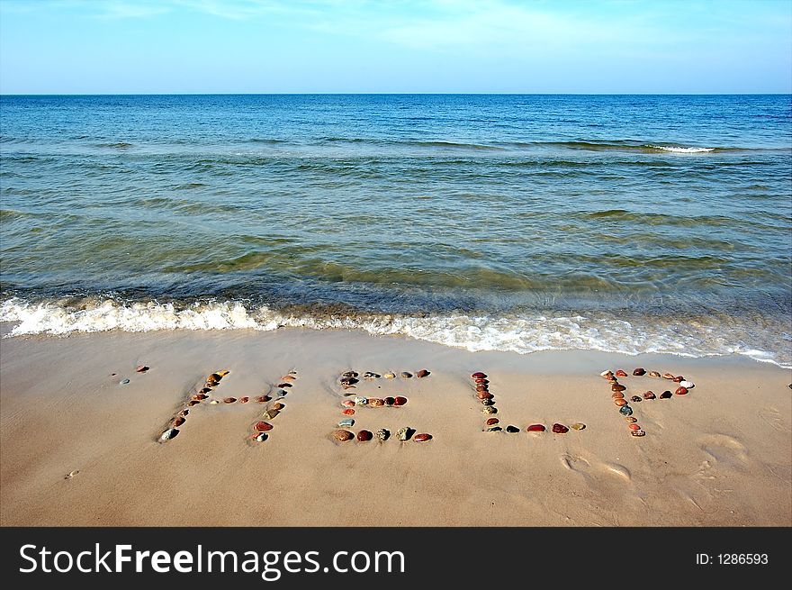 Word HELP on beach sand, made from rocks