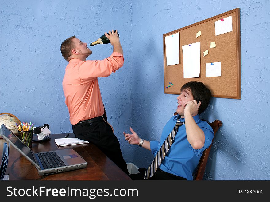 Two male workers drinking and goofing off on the job. Two male workers drinking and goofing off on the job