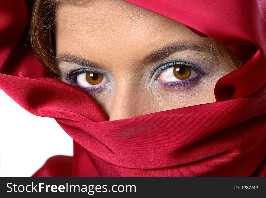 Woman with red scarf covering whole face except for eyes. Woman with red scarf covering whole face except for eyes