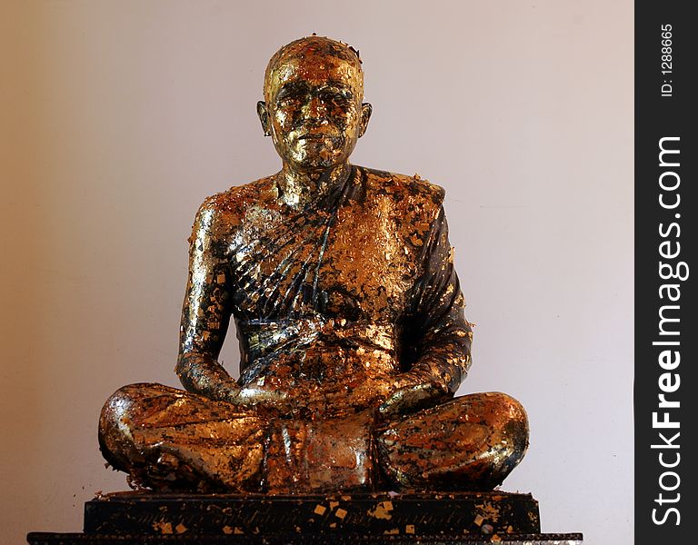 Golden Buddha statue with gold leaves pasted on.