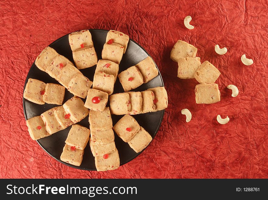 Fruit biscuits with casuenut in red background.