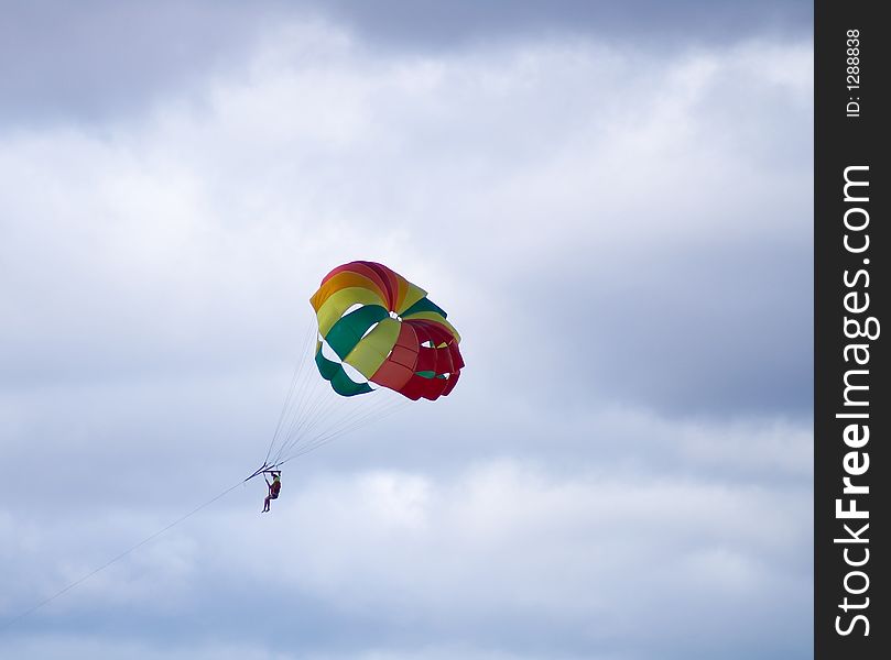 Multi-coloured parachute on a background of the cloudy sky. Multi-coloured parachute on a background of the cloudy sky
